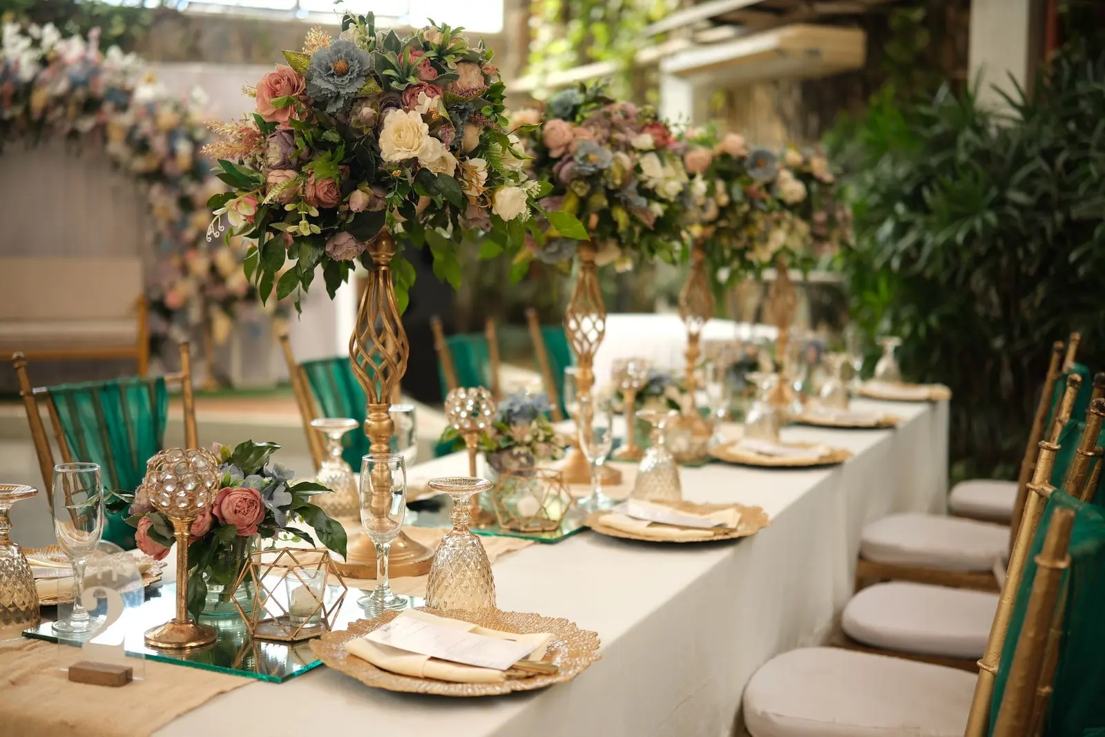 Sample styling: a long banquet table with gold chairs and floral runners