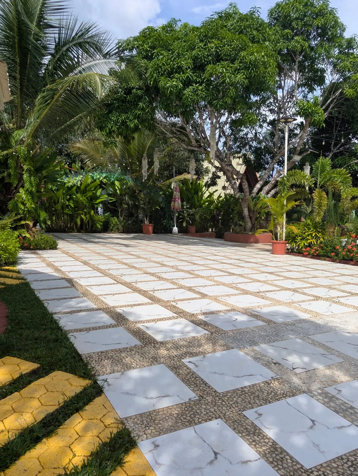 The stone-tile walkway through the garden lawn